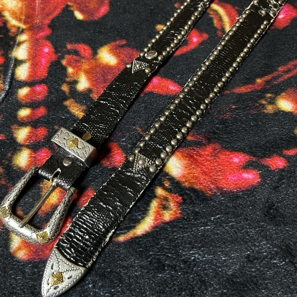 Silver grommet belt with gold accent on the buckle